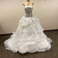 a white wedding dress on display in a room