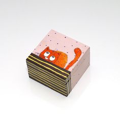 a small wooden box with an orange cat on it