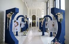 a hallway decorated with white and blue flowers, pictures and frames on the wall in front of them