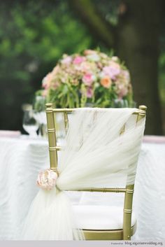 an image of a chair that is decorated with white tulle and pink flowers on it