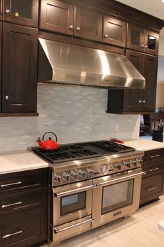 a stove top oven sitting inside of a kitchen next to wooden cupboards and counter tops