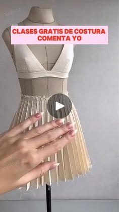 a woman's hand holding onto a dress on a mannequin stand with the words class gratis de coutra comenta yo