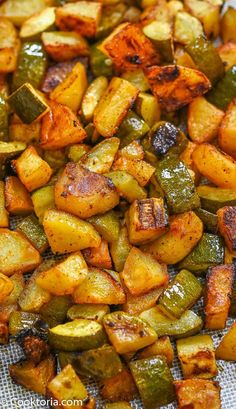 roasted potatoes and zucchini on a sheet of baking paper with text overlay