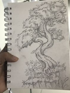 a person holding up a drawing of a tree