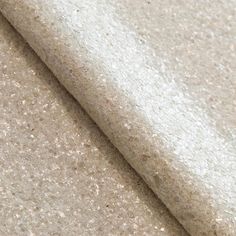 a close up view of a white fabric with small speckles on the surface