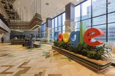 an office lobby with the word google spelled out in large letters on top of plants