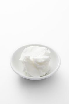 a white bowl filled with whipped cream on top of a table