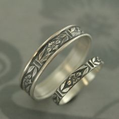 two silver rings with floral designs on them