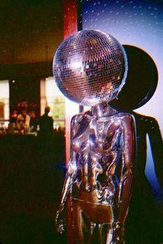 a disco ball sitting on top of a metal chair in front of a mirror wall