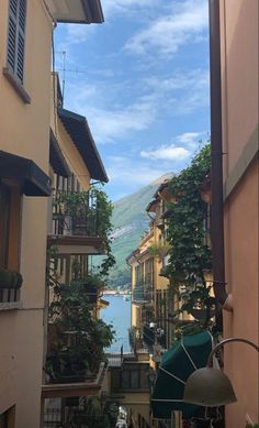 an alley way with several buildings and water in the backgrouds, on a sunny day