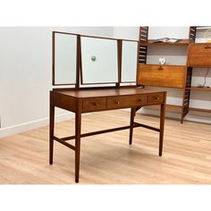 a wooden desk with two mirrors on it