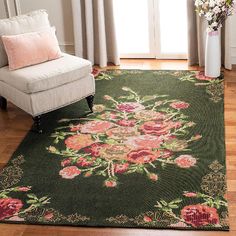 a living room area with a chair, rug and flowers on the floor in front of a window