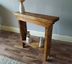 a wooden table with two vases on top of it and a rug underneath the table