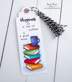 a bookmark with some books on it and a tassel attached to the tag