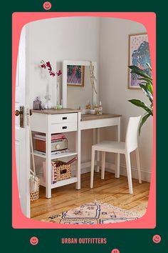 a white desk and chair in a room with pink trim on the wall, next to a potted plant