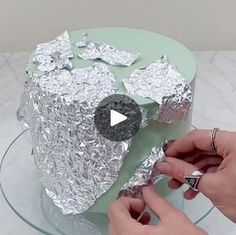 someone is decorating a cake with tin foil