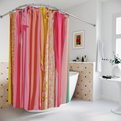 a bathroom with a bathtub, sink and shower curtain that has colorful stripes on it