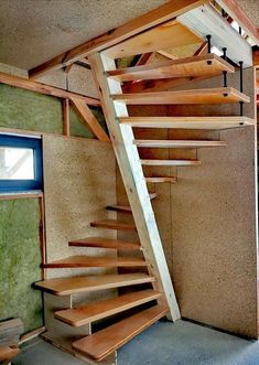 a wooden stair case in an unfinished room