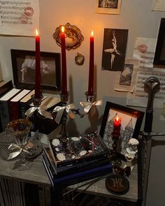 a table topped with candles and pictures next to other items on top of a wooden table