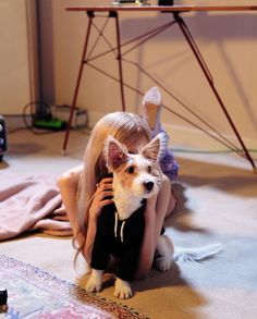 a woman sitting on the floor holding a dog