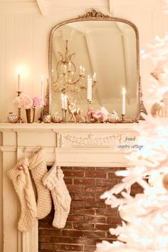 a fireplace with stockings hanging from the mantle and a mirror above it that is lit