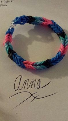 a bracelet with the name ama written in cursive writing on it, next to an ink pen