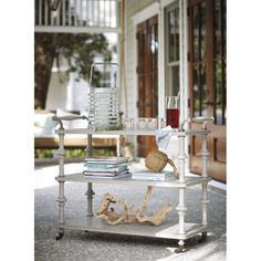 a coffee table with books and glasses on it in front of a house, outside