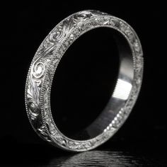 an intricately engraved wedding ring on a black background