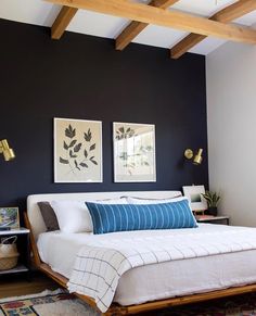 a bedroom with black walls and white bedding