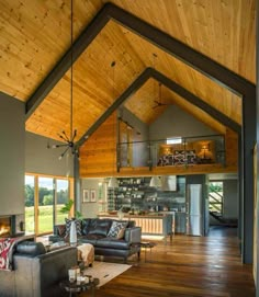 a living room filled with furniture and a fire place under a wooden ceiling mounted high in the wall