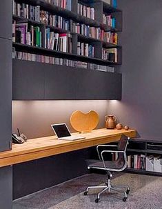 a desk with a laptop on it next to a bookshelf