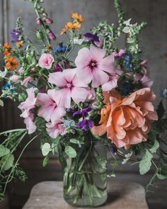 a vase filled with lots of different colored flowers