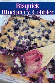 a blueberry cobbler with a wooden spatula in it and the words, bisquick blueberry cobbler