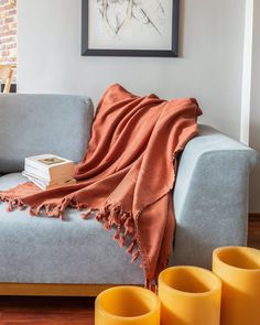 a living room with a gray couch and orange vases