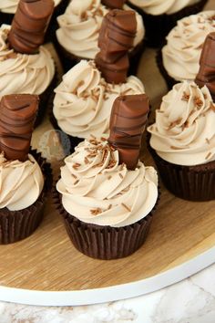 chocolate cupcakes with white frosting on a wooden platter