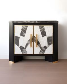 a black and white cabinet with gold handles