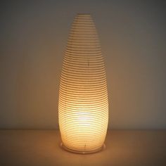 a light that is sitting on top of a table next to a vase with wavy lines in it