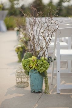 an image of a chair and flowers on the ground in front of a white bench