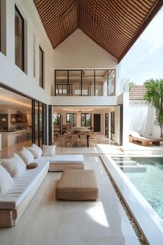 a living room filled with lots of furniture next to a swimming pool and covered patio