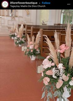 flowers in vases line the aisle of a church