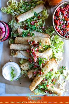 some food is laying out on a table next to a bowl of salad and dip