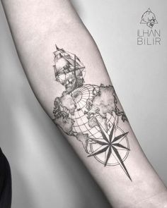 a man's arm with a map and compass tattoo on the left inner forearm