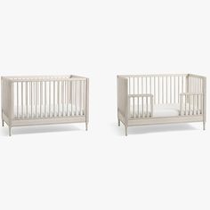 two white cribs sitting next to each other on a white surface with no sheets