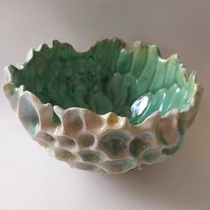 a green and white bowl sitting on top of a table