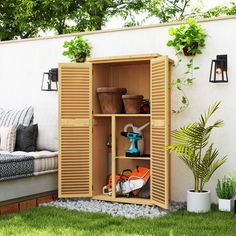 an outdoor storage unit with plants and tools in the corner, next to a bench