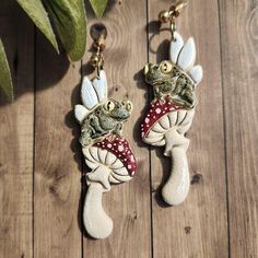 two ceramic frog figurines hanging from hooks