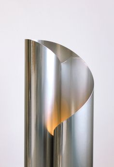 a large metal object sitting on top of a wooden table next to a white wall