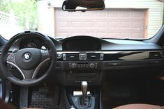 the interior of a car with dashboard, steering wheel and dash board in front of a garage door