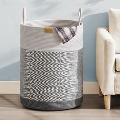 a white and gray basket sitting next to a chair