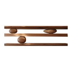 two wooden shelves with three balls on each shelf and one is hanging from the wall